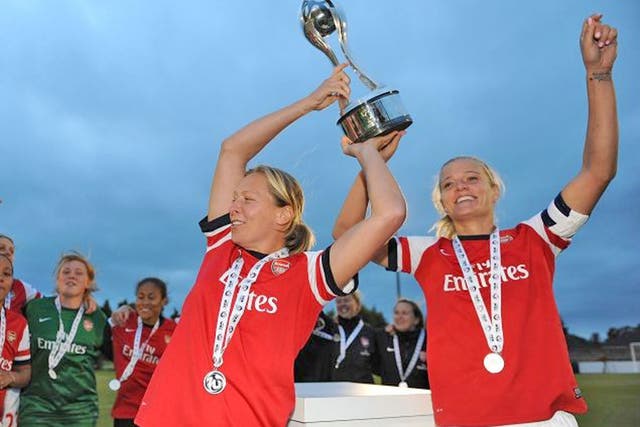 Arsenal’s Jayne Ludlow and Katie Chapman lift the trophy