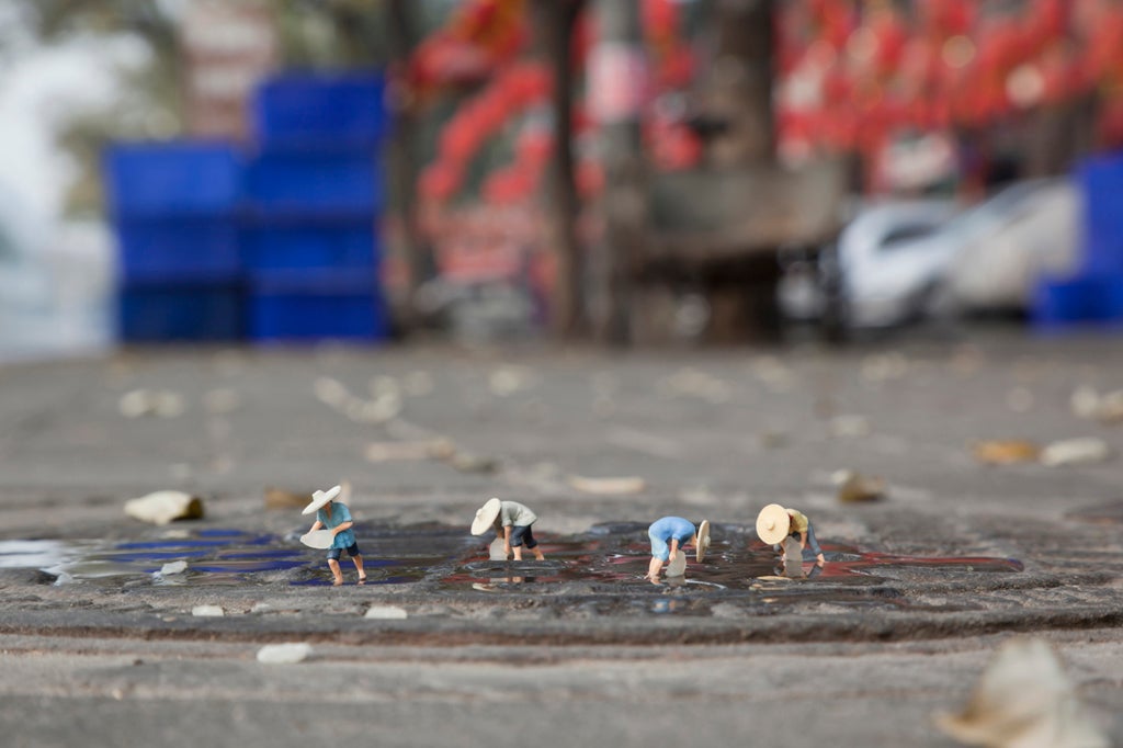 Only the sharp-eyed would spot Slinkachu's tiny field-workers on the damp pavement