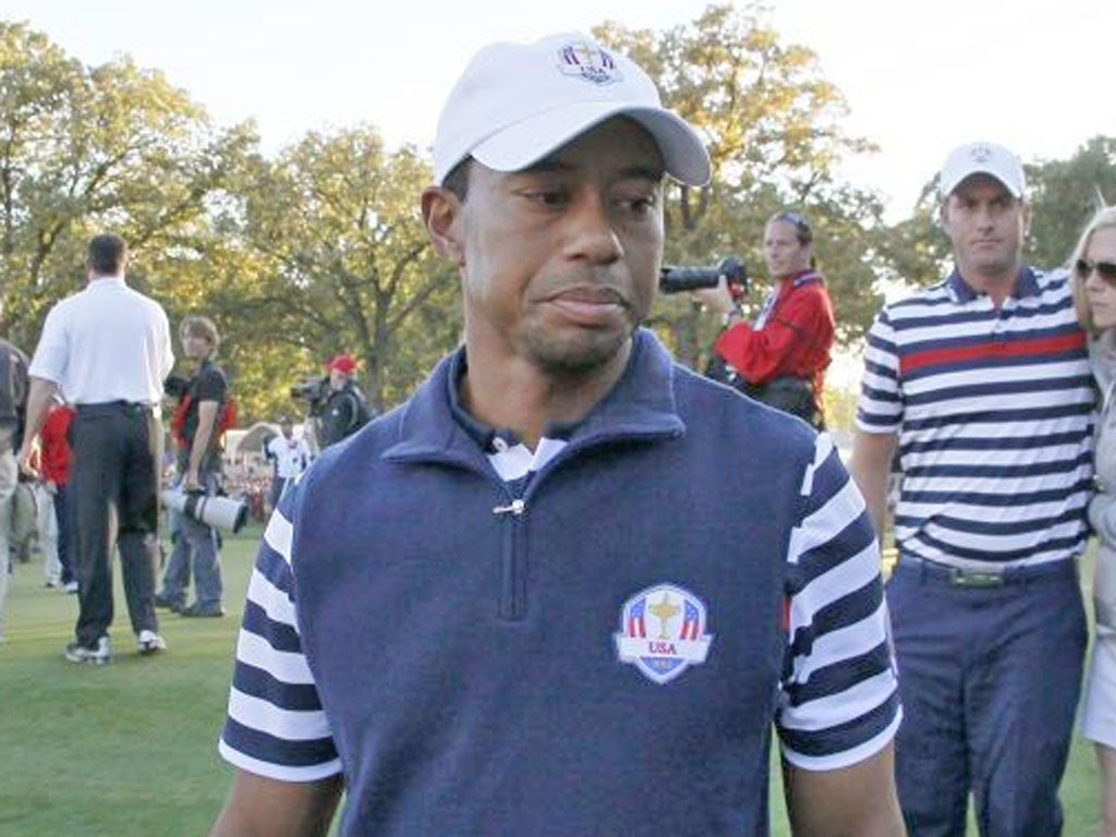 USA's Tiger Woods walks off the course as Europe celebrates their win at the Ryder Cup