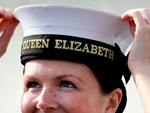 Royal Navy Leading Hand Claire Butler is presented with the first 'cap tally' for being the first crew member to board new aircraft carrier HMS Queen Elizabeth