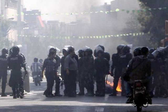 Iranian riot police move in as garbage is set on fire by protestors in central Tehran