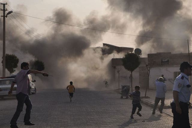 Smoke rises over the streets after an mortar bomb landed from Syria in the border village of Akcakale