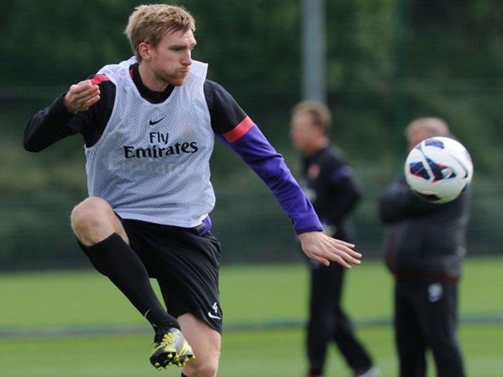 Per Mertesacker trains yesterday after recovering from a virus