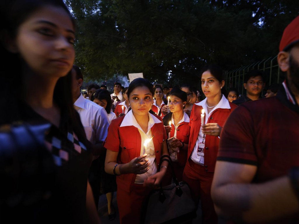 Employees of Kingfisher Airlines, owned by Vijay Mallya, inset, take part in a candlelight vigil after the wife of a colleague killed herself