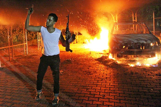11 September 2012: An armed man waves his rifle as buildings and cars are engulfed in flames in the US consulate compound in Benghazi