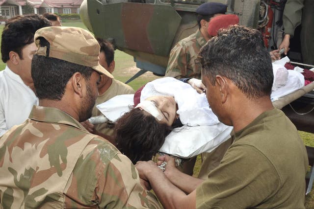 Pakistani soldiers shift injured Malala Yousafzai from a helicopter at an army hospital following an attack by gunmen in Peshawar