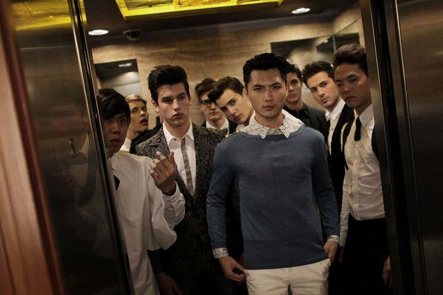 Models cram into an elevator before taking part in a fashion show at the Singapore Men's Fashion Week 2011