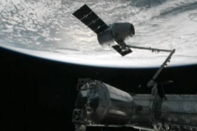 The capture of the Dragon capsule by a robot arm on the International Space Station