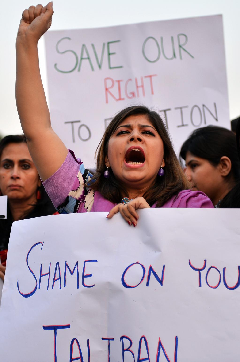 Pakistani civil society activists carry placards as they shout anti-Taliban slogans during a protest rally against the assassination attempt on Malala Yousafzai, in Islamabad
