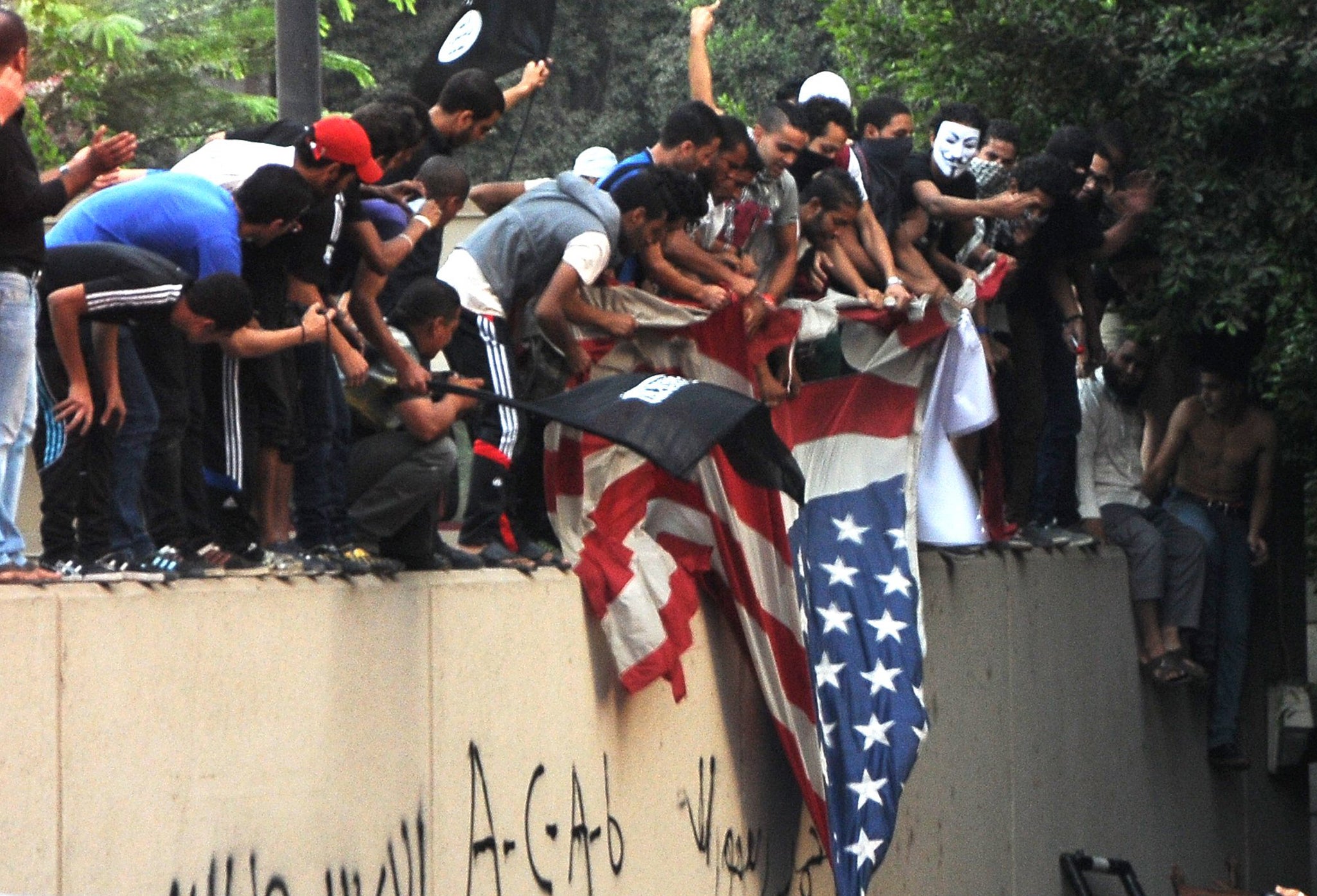 Egyptian protesters tear down the US flag at the US embassy in Cairo on September 11, 2012