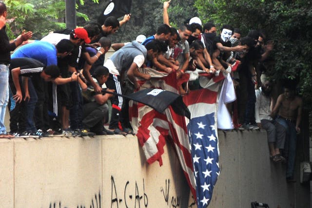 Egyptian protesters tear down the US flag at the US embassy in Cairo on September 11, 2012