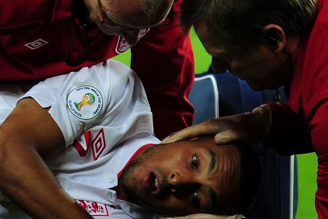 Theo Walcott is treated after colliding with Aldo Simoncini