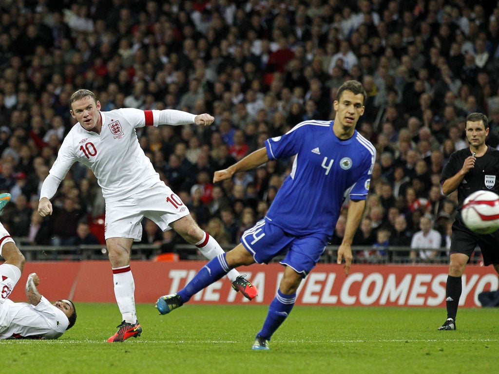 Leading by example: Wayne Rooney, with armband, scores his second goal against San Marino on Friday