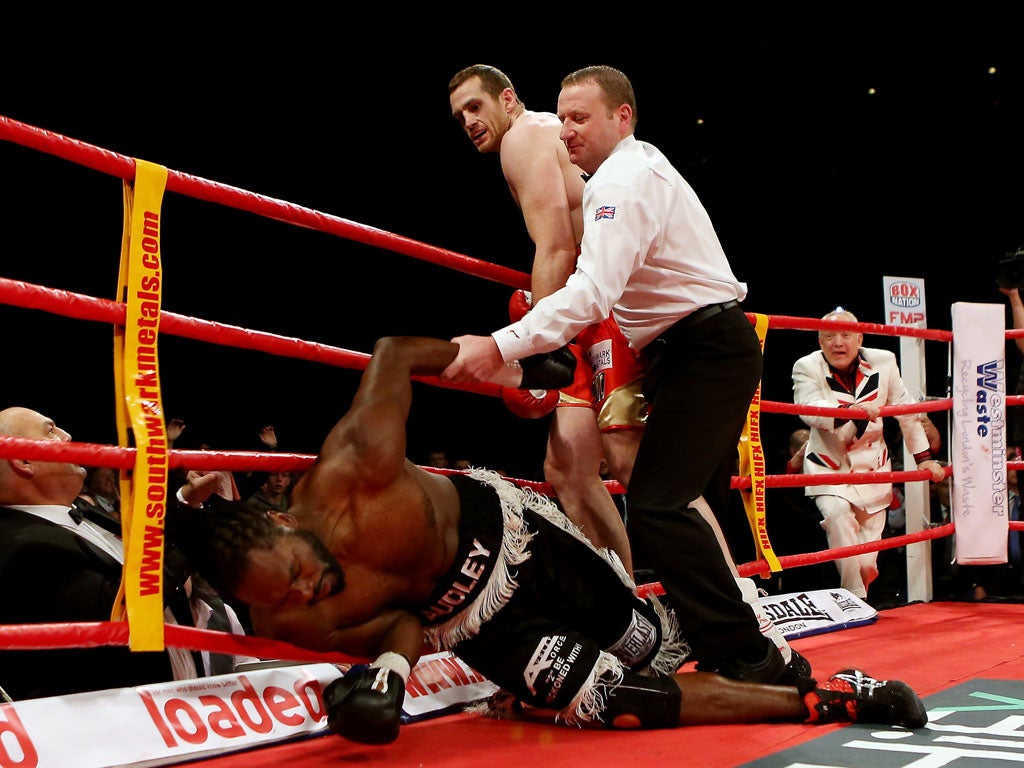 Sunk without trace: Referee Howard Foster comes to the aid of Audley Harrison after David Price knocks him down