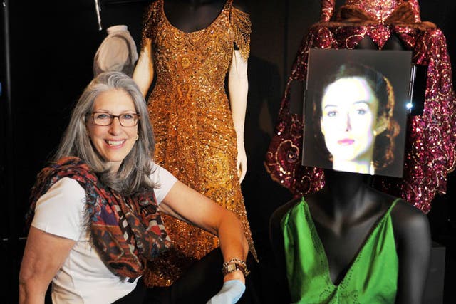 Hollywood costume designer and curator of the Hollywood Costume exhibition Deborah Nadoolman Landis (left), sits with the costumes worn by (clockwise) Barbra Streisand in 'Hello Dolly', Ginger Rogers in 'Lady in the dark' , and Keira Knightley in Atonement', before the opening of the 130 costumes on display on the 20th October at the Victoria & Albert Musuem in London