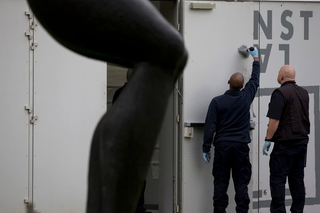 Forensic experts dust the inside of a back door for fingerprints at Kunsthal museum in Rotterdam, Netherlands, Tuesday Oct. 16, 2012.