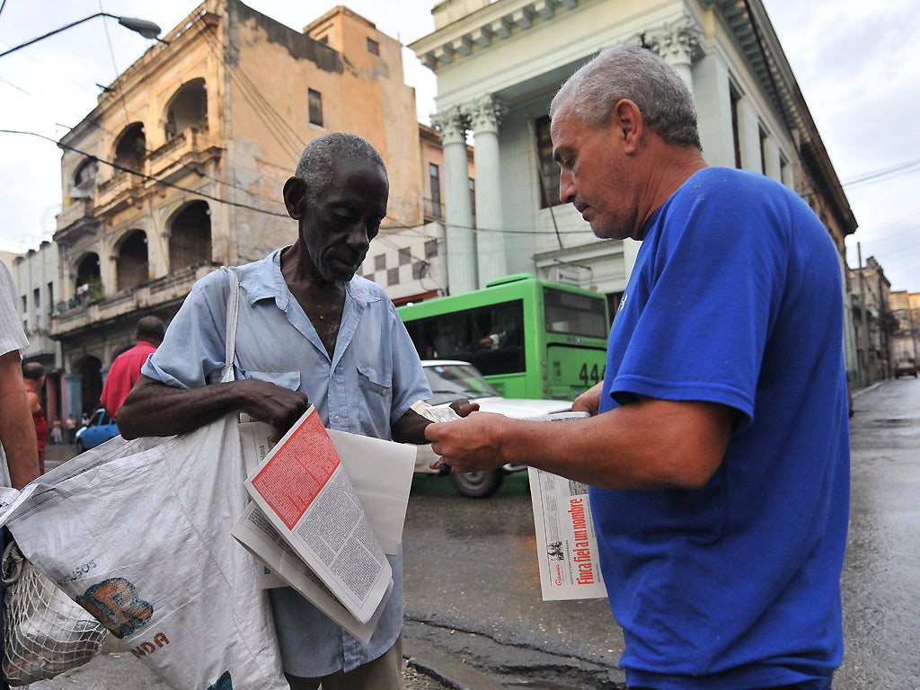 A man buys a copy of Granma newspaper to read changes that mean Cubans will no longer require exit permits for foreign travel from 14 January 14 - the latest in a trickle of reforms enacted on the communist-ruled island