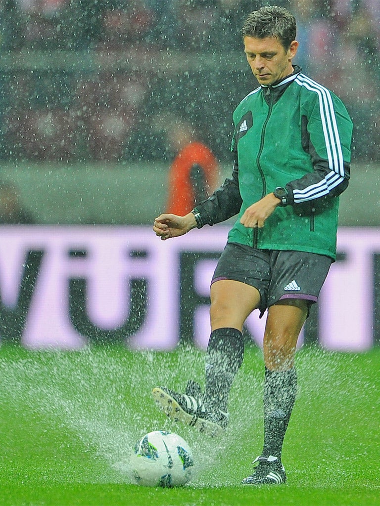Referee Gianluca Rocchi tests last night’s waterlogged pitch