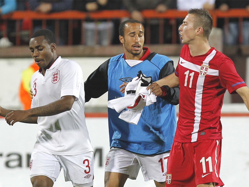 Andros Townsend separates his team-mate Danny Rose and Sasa Markovic of Serbia