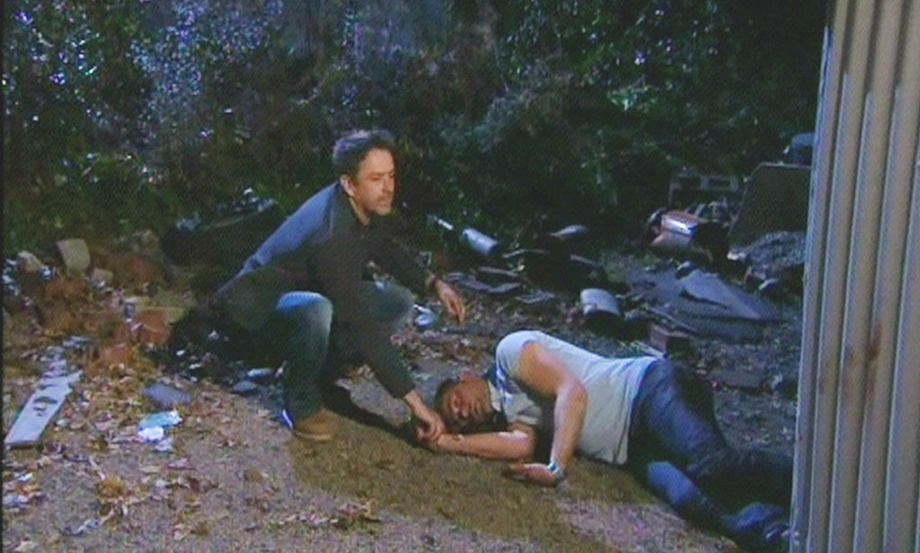 Carl King played by Tom Lister , lies on the floor after being hit with a brick for a second time by Cameron Murray played by Dominic Power, following an attack by Chastity Dingle played by Lucy Pargeter
