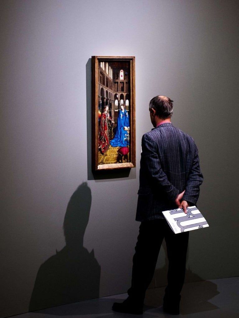 A visitor looks at Jan Van Eyck's Annunciation in Rotterdam