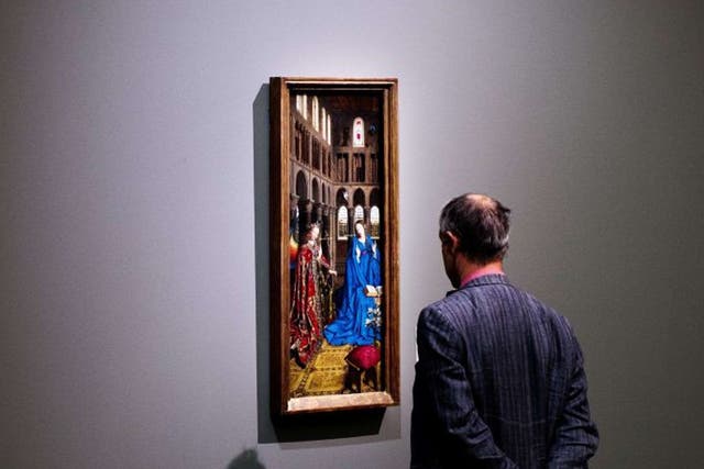 A visitor looks at Jan Van Eyck's Annunciation in Rotterdam