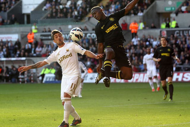 Maynor Figueroa of Wigan Athletic wins the arial battle for the ball with Pablo Hernandez of Swansea