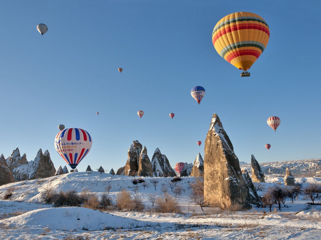 High life: Hot-air balloons float above snow-covered Cappadocia