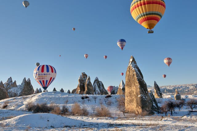 High life: Hot-air balloons float above snow-covered Cappadocia