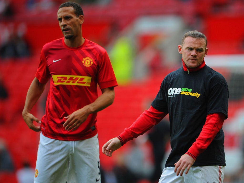 Split decision: Rio Ferdinand (left) chooses not to wear the Kick It Out T-shirt before Manchester United's game against Stoke at Old Trafford while Wayne Rooney takes the opposite view