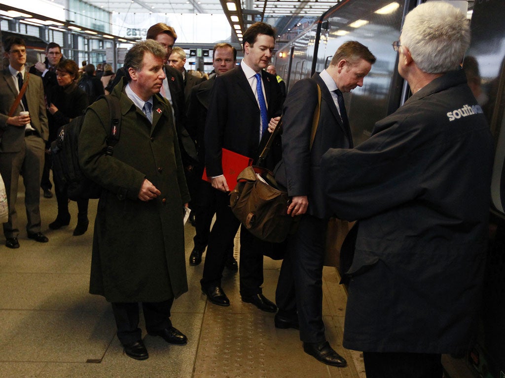 Britain's Chancellor of the Exchequer George Osborne (C) boards a train at St Pancras rail station with Education Secretary Michael Gove (2nd, R).