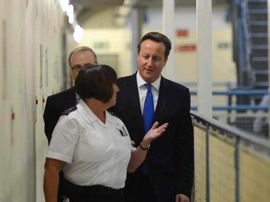 David Cameron is escorted around C wing during his visit to Wormwood Scrubs Prison in west London yesterday