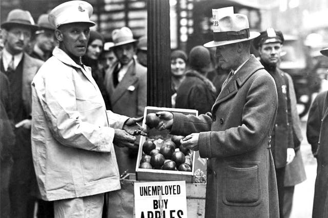 A jobless man sells apples on a US street during the Depression