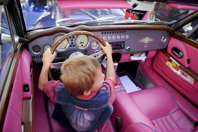 A Kosovar child sits in a Morgan car during a parade of Old Timer Cars in Pristina on May 31, 2009
