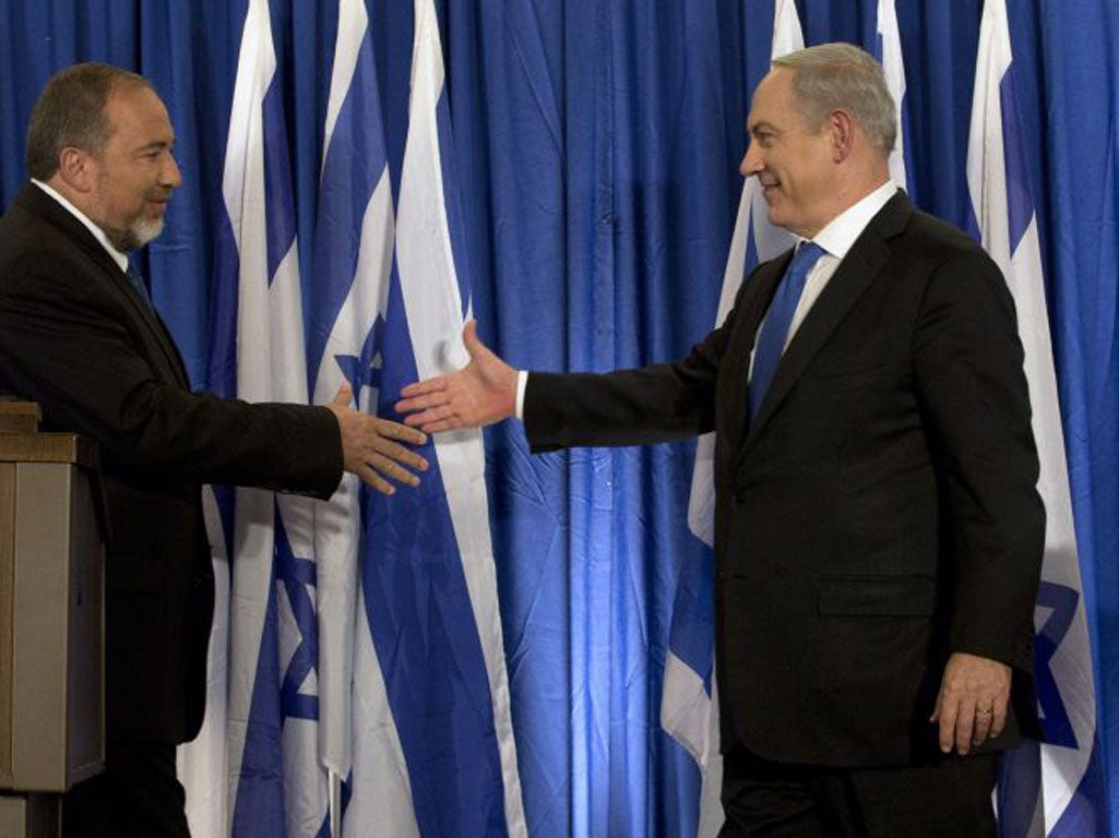 Israel’s Foreign Minister, Avigdor Lieberman, left, and Prime Minister Benjamin Netanyahu seal the deal in Jerusalem