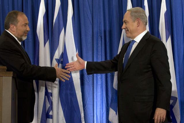 Israel’s Foreign Minister, Avigdor Lieberman, left, and Prime Minister Benjamin Netanyahu seal the deal in Jerusalem
