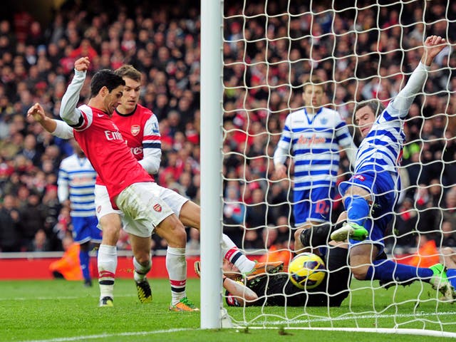 Mikel Arteta of Arsenal pokes the ball past Ryan Nelsen of QPR to score the opening goal