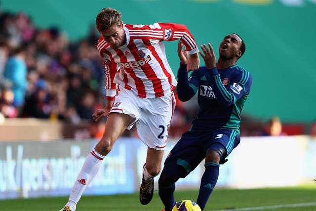 Peter Crouch of Stoke and Danny Rose of Sunderland challenge for the ball