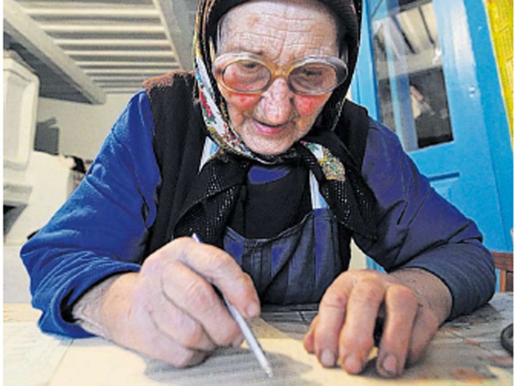 An elderly Ukrainian voter checks her ballot in the village of Rusaki