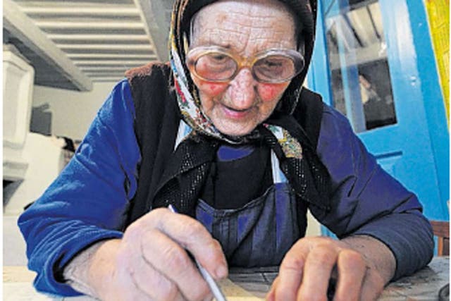 An elderly Ukrainian voter checks her ballot in the village of Rusaki