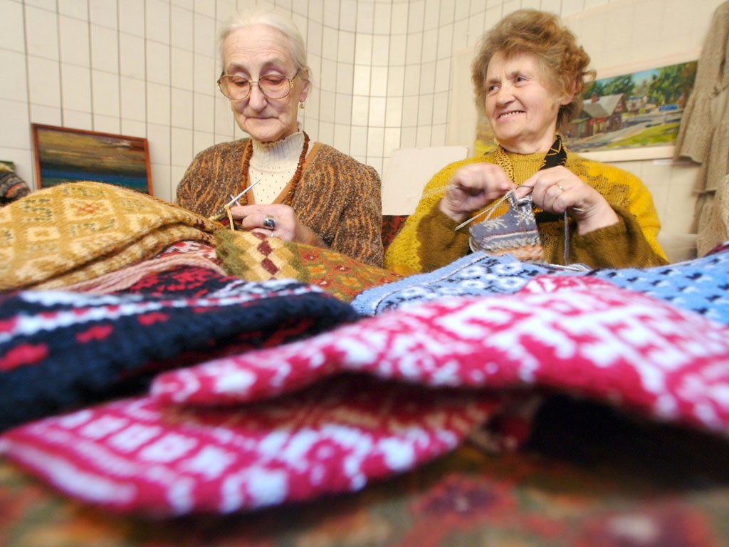 Picture taken 12 November 2006 shows old women knitting mittens to be packed by volounteers as Welcome Gifts for the Nato Summit guests, in Riga, Latvia.