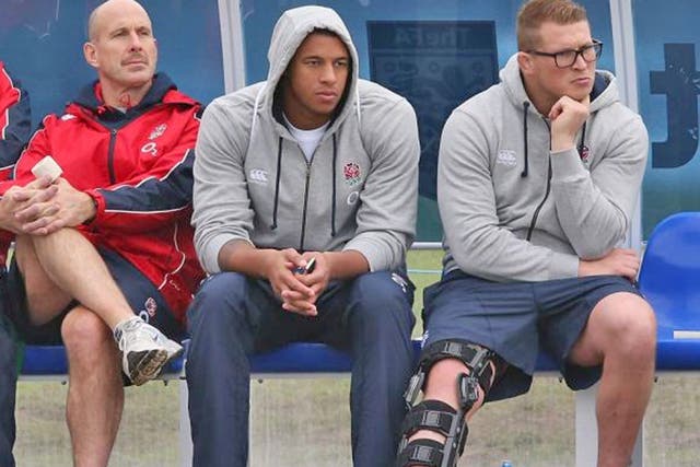 Leg heavily strapped, Dylan Hartley watches England training yesterday with Courtney Lawes