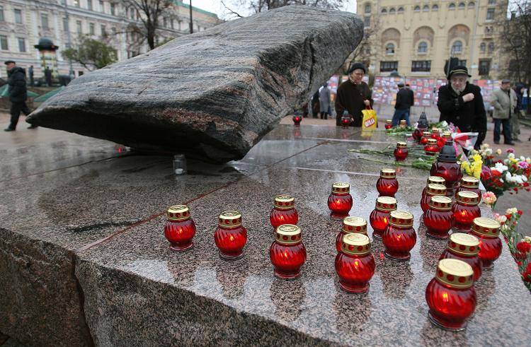 People place candles near the Solovetsky stone in front of the FSB, formerly KGB, headquaters in Moscow