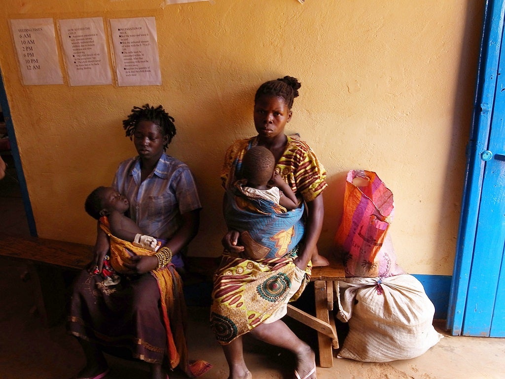 Congolese women and their children with malaria wait to see a doctor