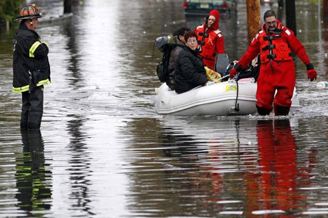 Emergency personnel rescue residents from flood waters brought on by Hurricane Sandy in Little Ferry