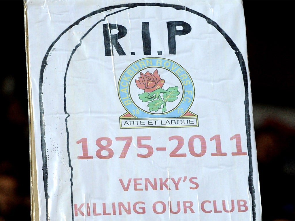 A Blackburn Rovers fan holds up a poster in protest against the club's owners Venkys