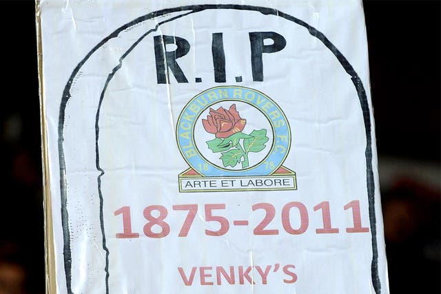 A Blackburn Rovers fan holds up a poster in protest against the club's owners Venkys
