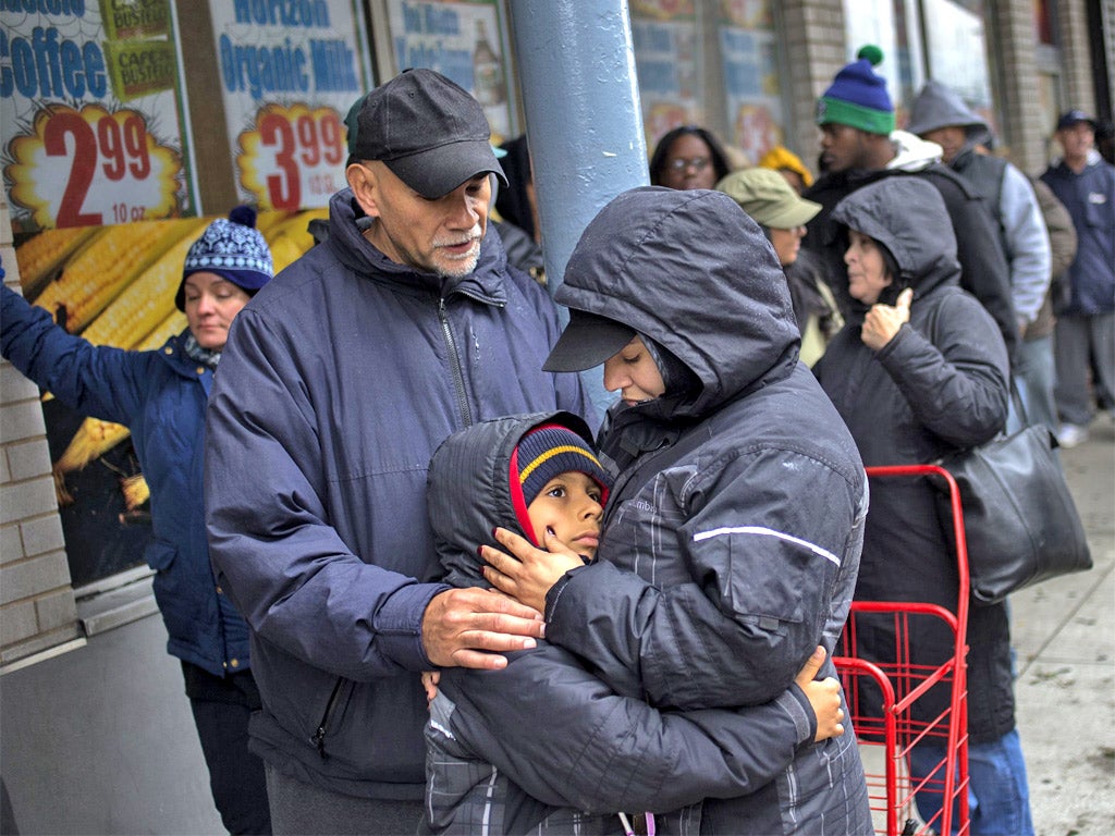 New Yorkers queue for food at a grocery store in Lower Manhattan yesterday