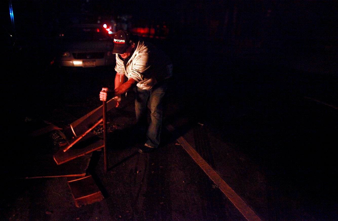 A New Yorker breaks up wood for a bonfire after Hurricane Sandy left the city without power