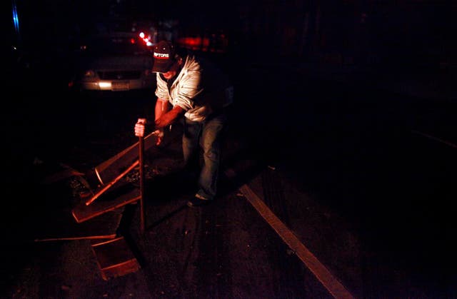 A New Yorker breaks up wood for a bonfire after Hurricane Sandy left the city without power